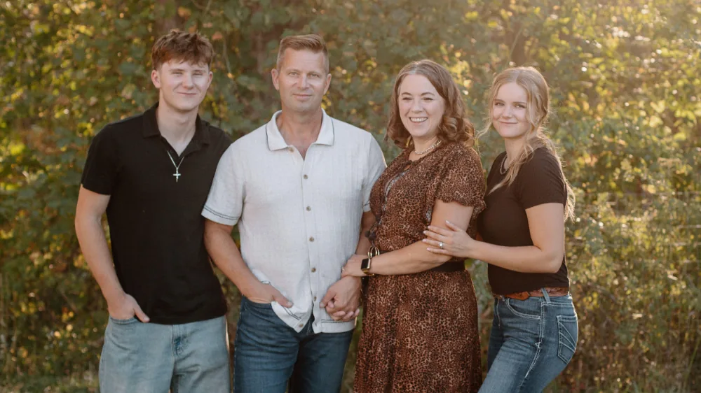 Patrick Kapenga posing outdoors with his wife Cherith, daughter Christelle, and son Xander